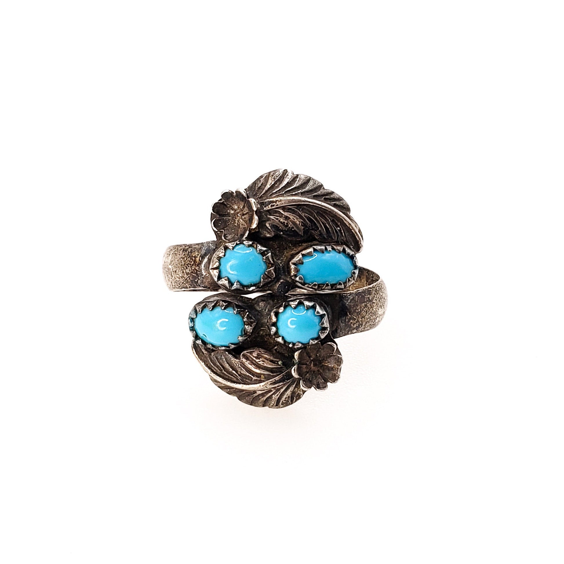 A vintage sterling silver ring with blue turquoise cabochons and feather accents, adjustable shank.