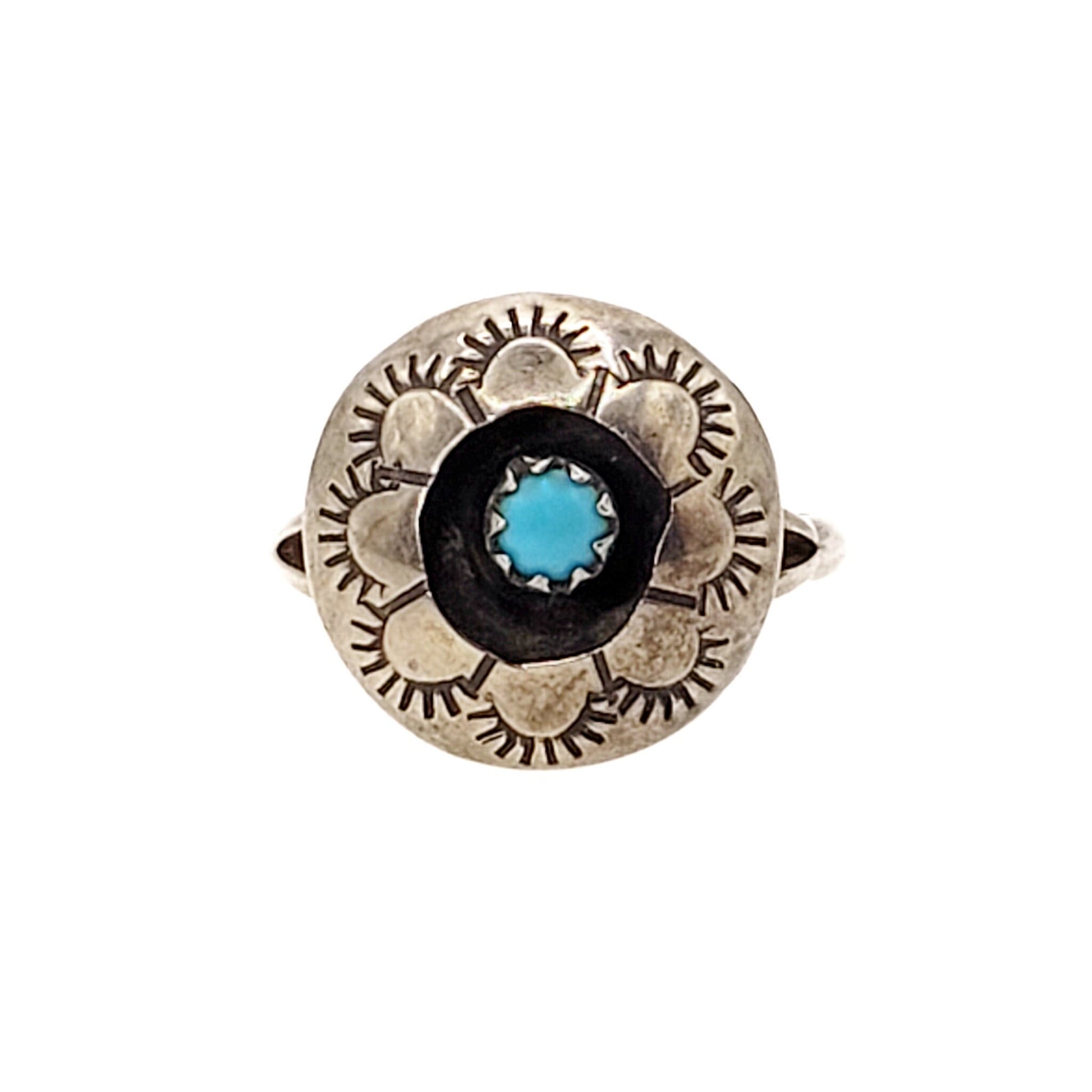 A vintage 1980s sterling silver ring with a central blue turquoise cabochon and geometric floral design.