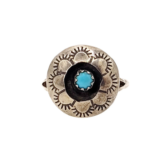 A vintage 1980s sterling silver ring with a central blue turquoise cabochon and geometric floral design.