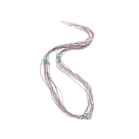 A vintage 1970s sterling silver and blue turquoise bead liquid silver necklace with multiple strands.