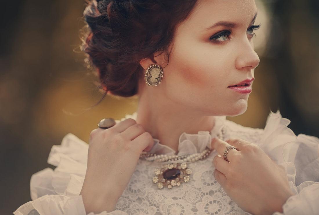 Woman in high neck white shirt raises her hands with jewelry