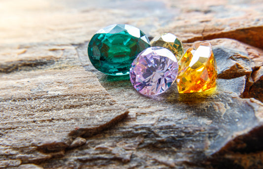 green, lavender, and orange gemstones on a rock during sunset