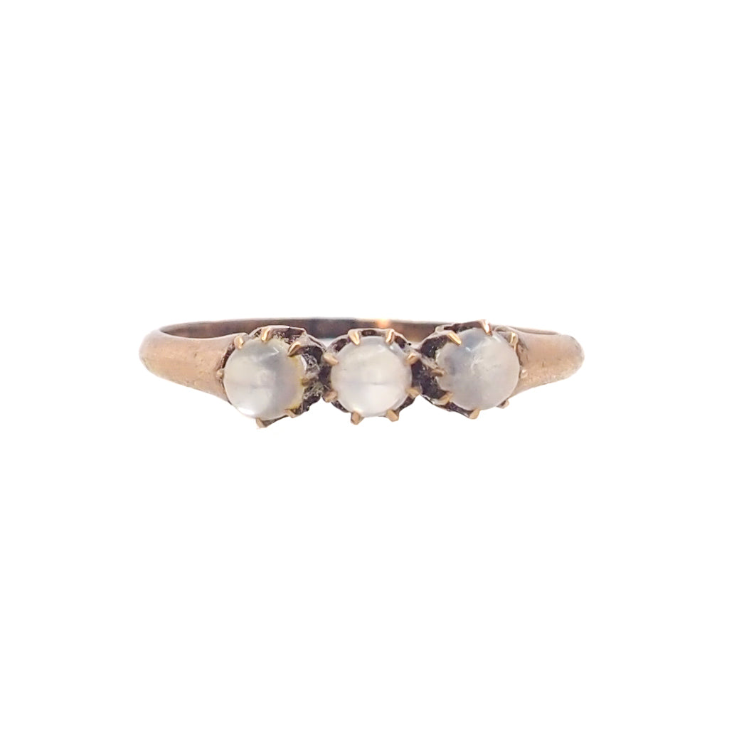 Three-stone ring with moonstones on a white background