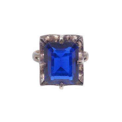 Ring with a blue gemstone and silver band on a white background