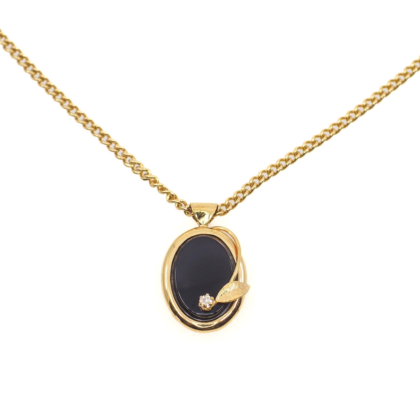 Gold necklace with a black pendant on a white background