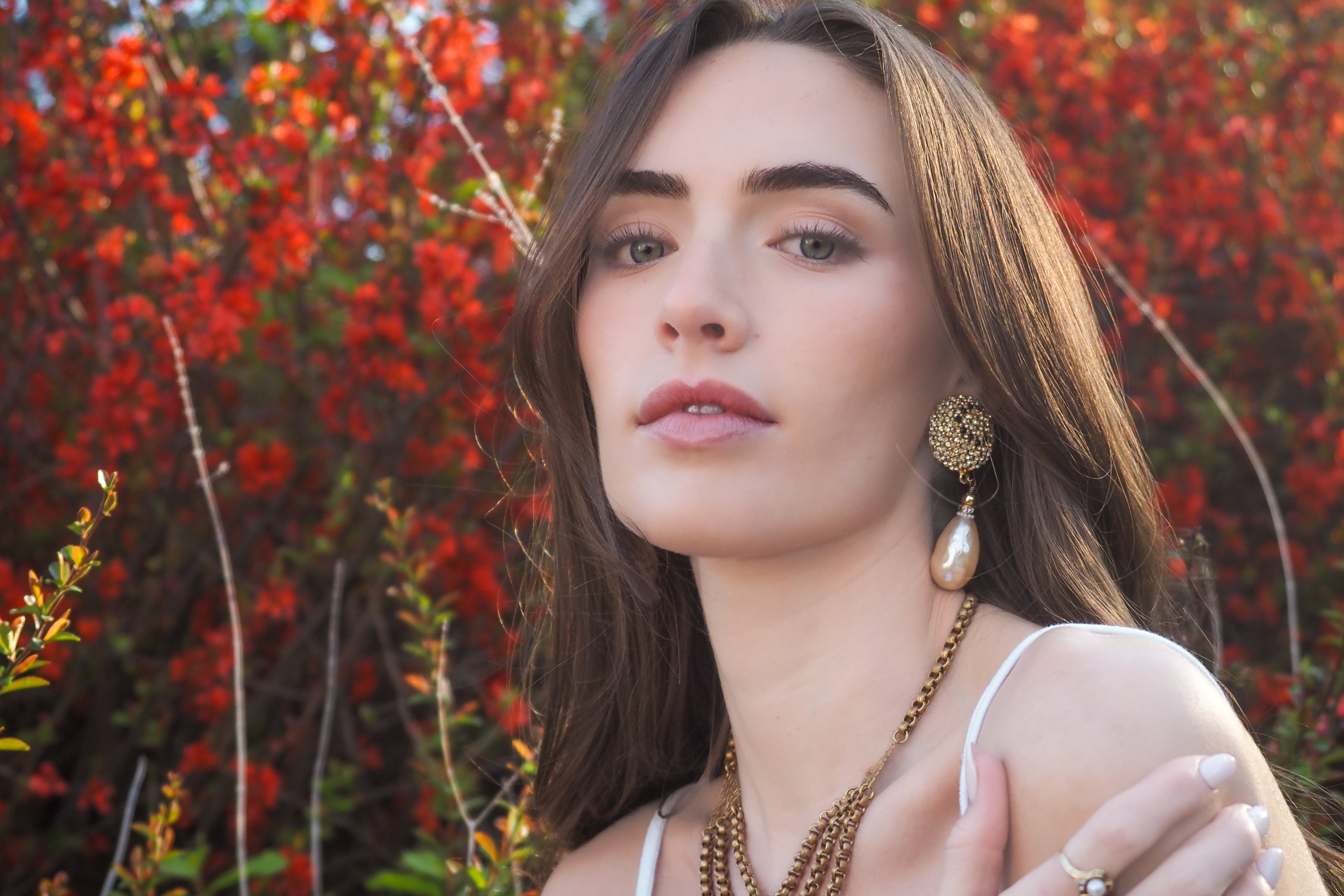 Woman with jewelry in front of a red floral background